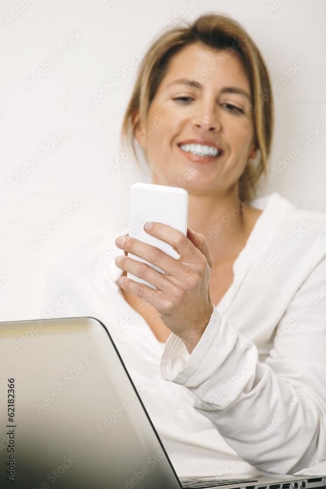 Mature business woman sending a message with smartphone. Mature business woman sending a message with smartphone.