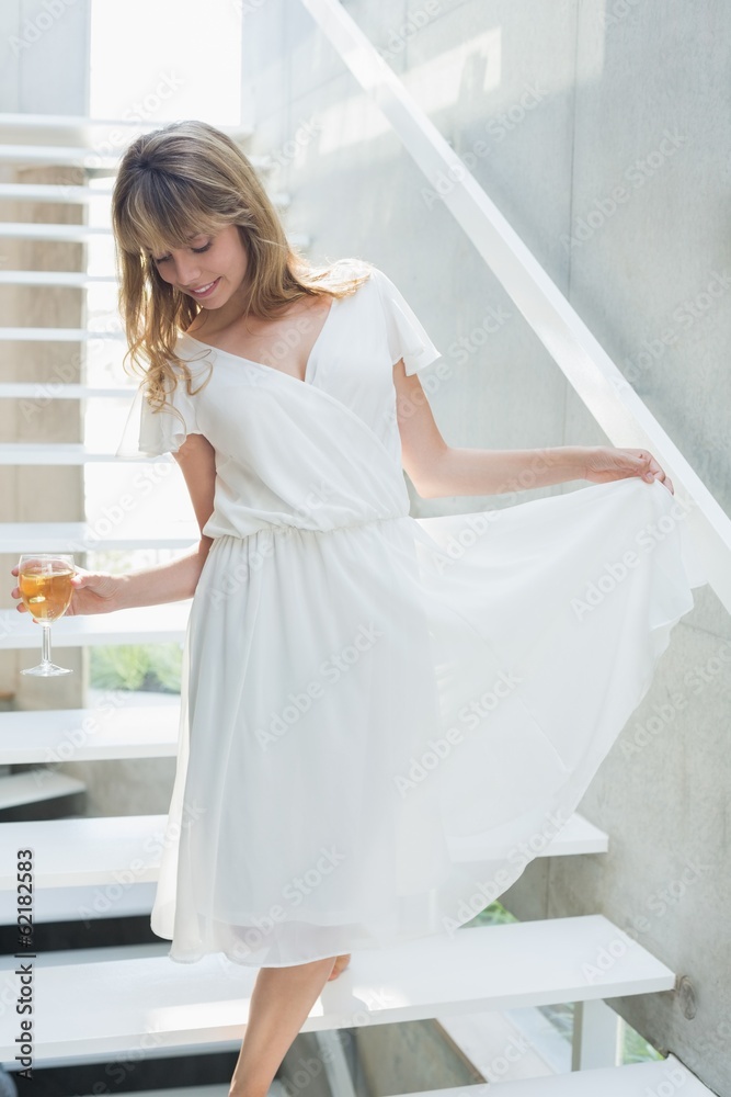 Thoughtful beautiful woman with wine glass on stairs Thoughtful beautiful woman with wine glass on stairs