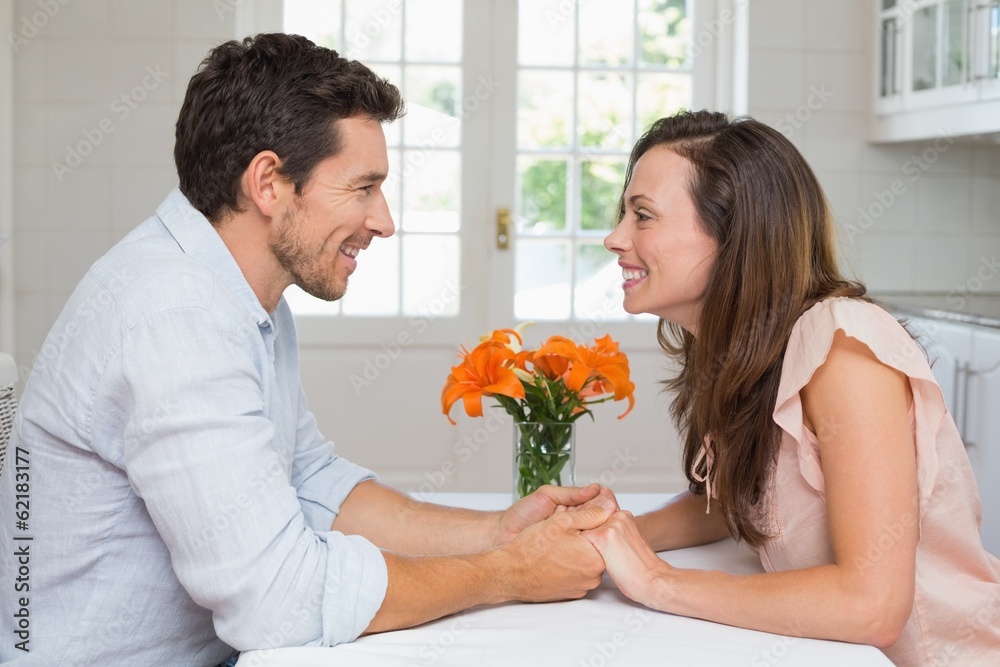 Loving young couple holding hands in kitchen Loving young couple holding hands in kitchen