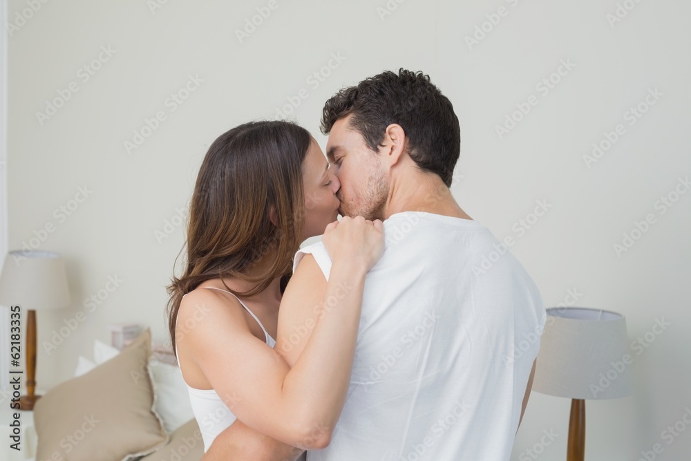 Loving young couple kissing at home Loving young couple kissing at home