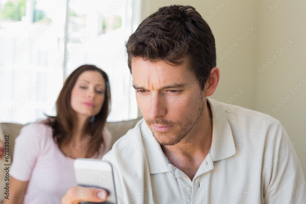 woman looking at man text messaging