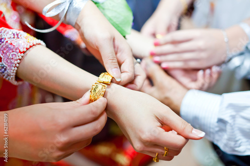 Elderly relatives presenting the golden bracelet as a blessing i