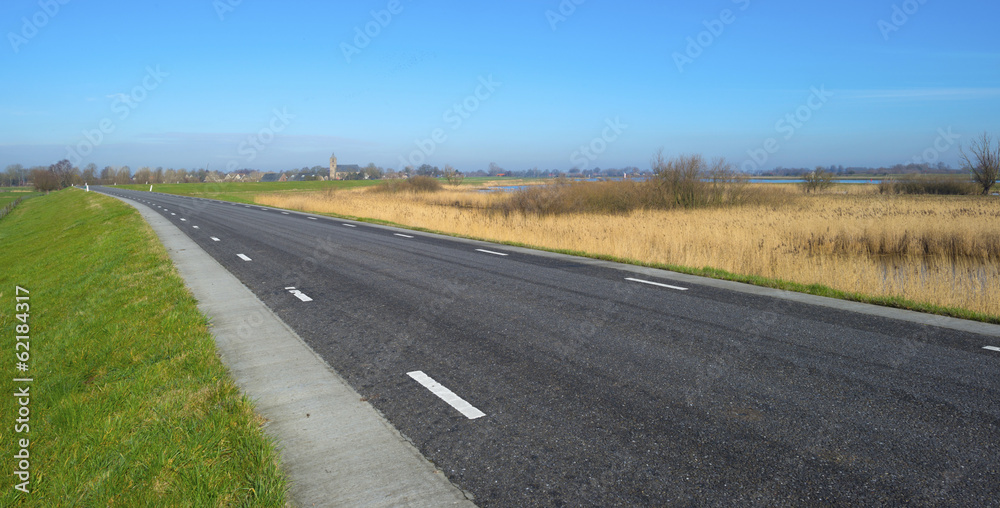 Road on a dike along a river in winter