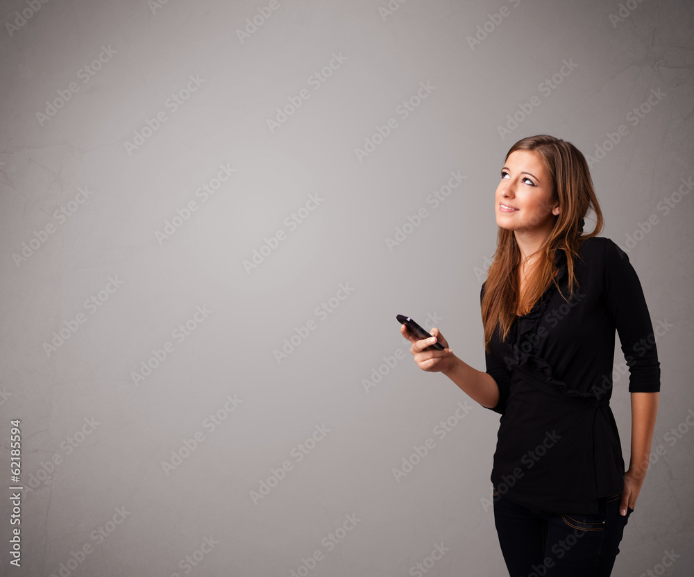 young lady standing and holding a phone with copy space young lady standing and holding a phone with copy space