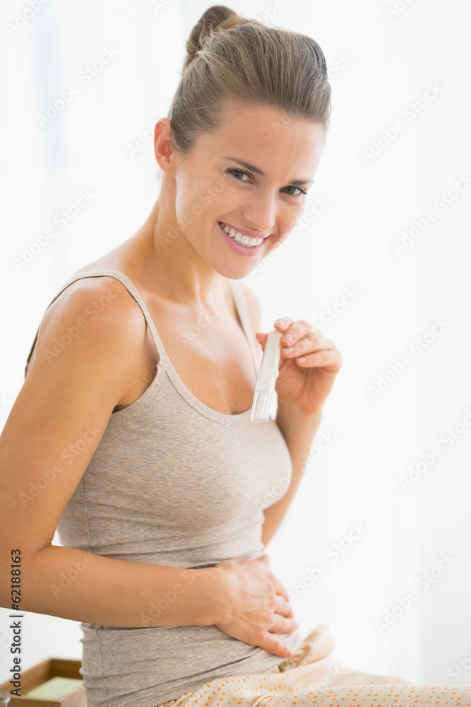 Portrait of happy young woman with pregnancy test Portrait of happy young woman with pregnancy test