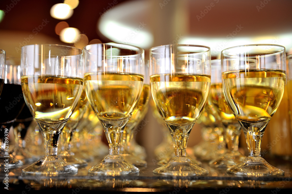 Closeup of glasses of white wine in a row on a table Closeup of glasses of white wine in a row on a table