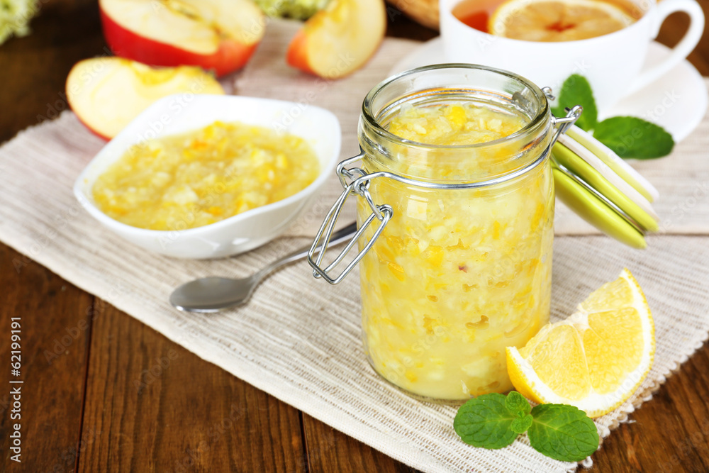Tasty lemon jam with cup of tea on table close-up