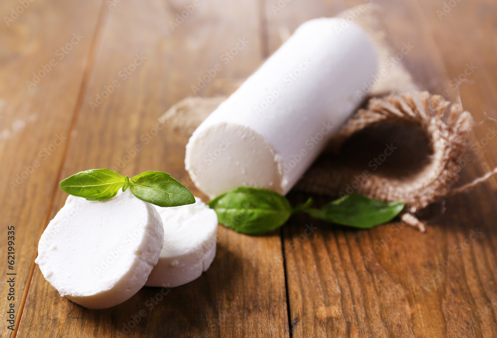 Tasty bushe cheese with basil, on wooden table Tasty bushe cheese with basil, on wooden table