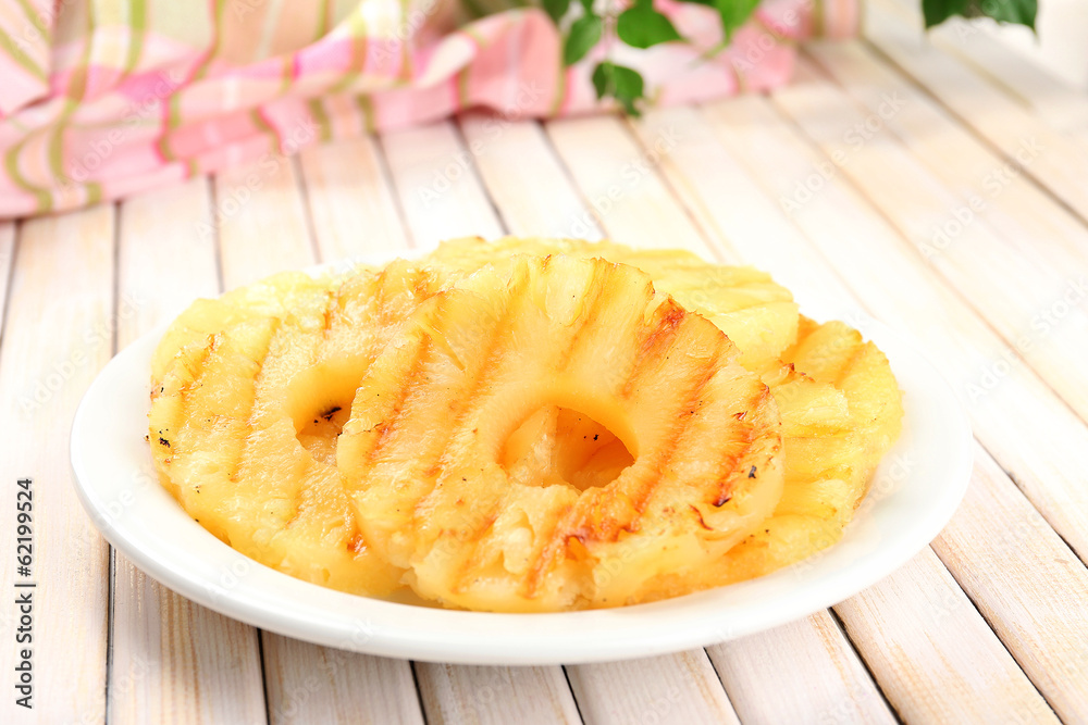 Juicy grilled pineapple on plate on table close-up Juicy grilled pineapple on plate on table close-up