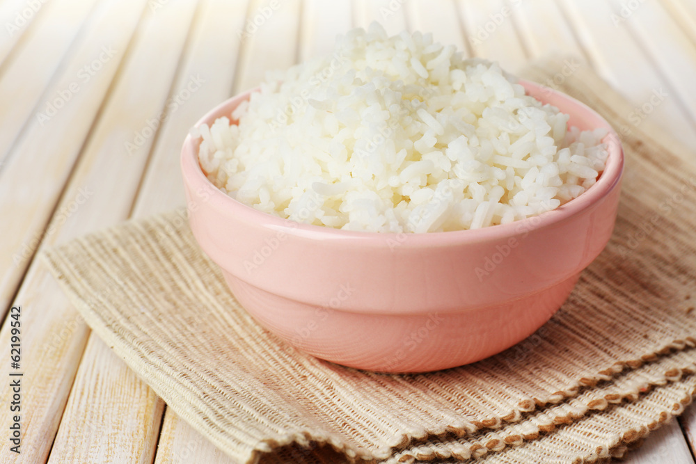 Cooked rice in bowl on wooden background Cooked rice in bowl on wooden background