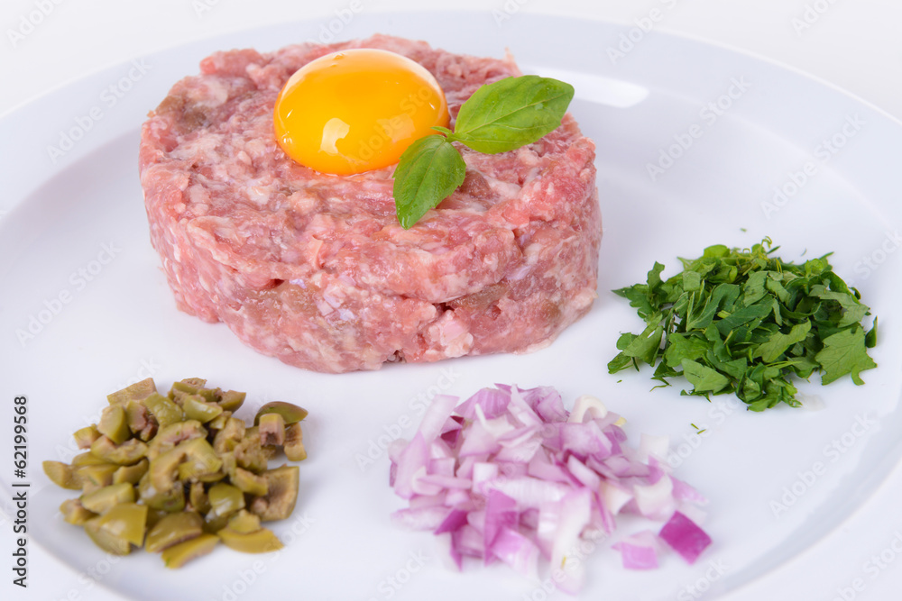 Delicious steak tartare with yolk on plate close-up Delicious steak tartare with yolk on plate close-up