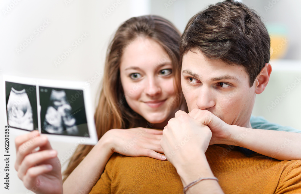 Beautiful couple watching with emotion ultrasound pictures of th Beautiful couple watching with emotion ultrasound pictures of th