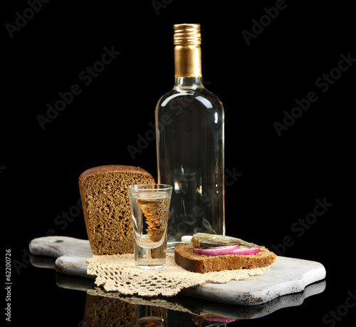 Bottle of vodka, sandwich with salted fish and glasses