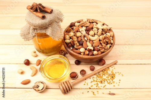 Sweet honey and different nuts on wooden table