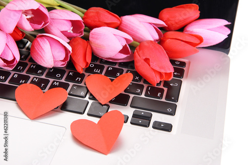 Fototapeta Naklejka Na Ścianę i Meble -  Red hearts and flowers on computer keyboard close up