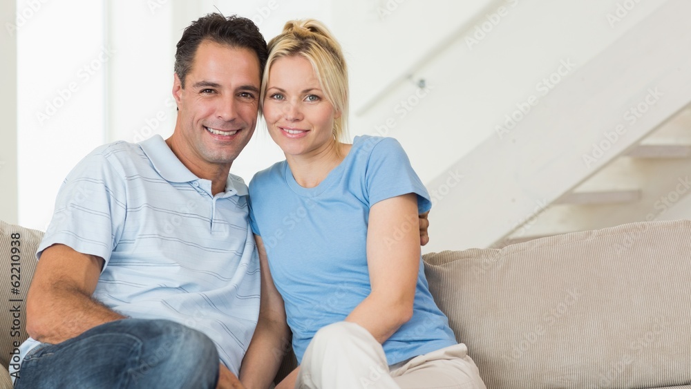 Portrait of a loving couple sitting on sofa in living room Portrait of a loving couple sitting on sofa in living room