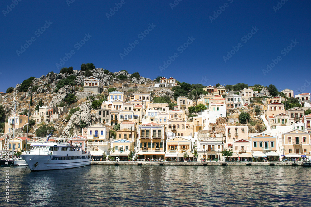 Colorful houses lining the harbor at Symi, Greece
