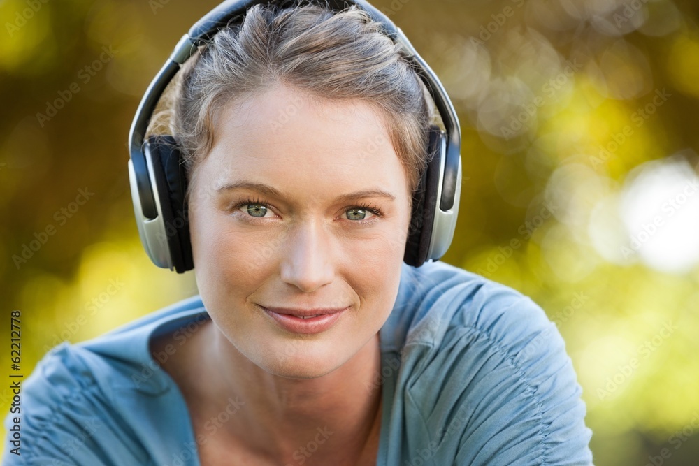 Close-up of beautiful woman enjoying music in park Close-up of beautiful woman enjoying music in park