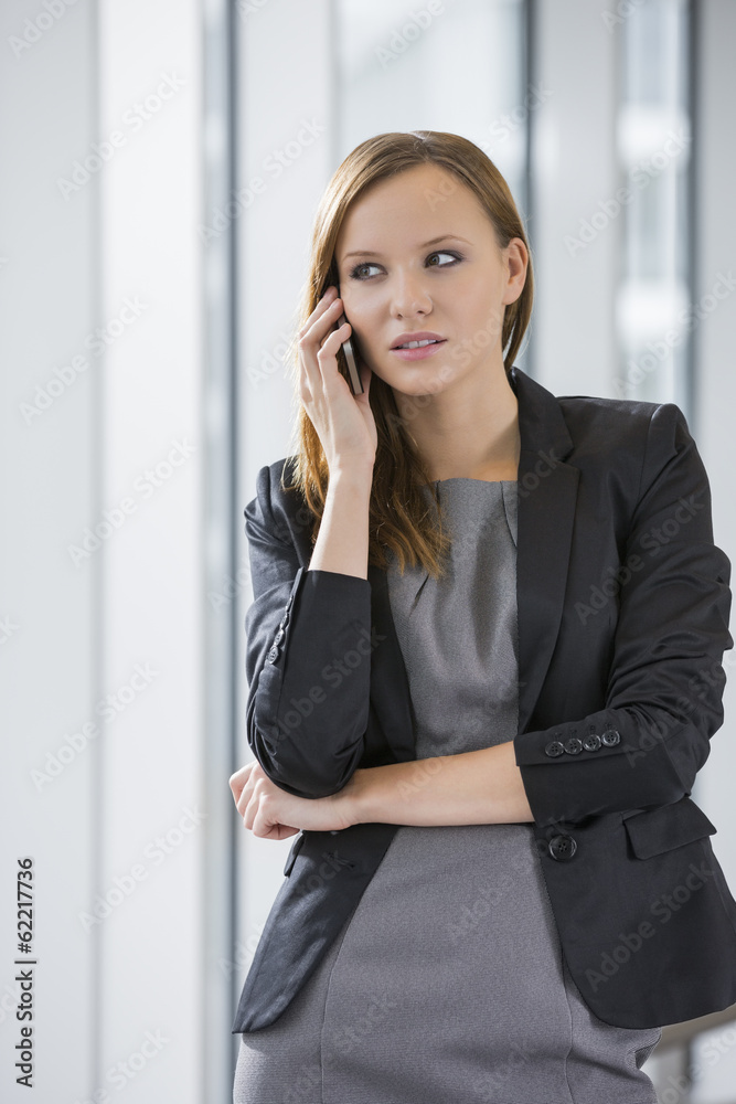 Beautiful businesswoman using cell phone in office Beautiful businesswoman using cell phone in office