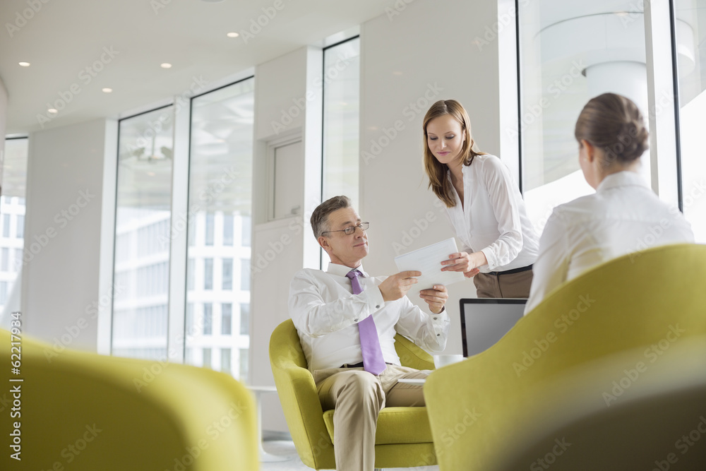 Business people working in office lobby Business people working in office lobby