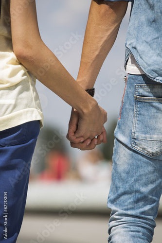 Mid section of couple holding hands outdoors