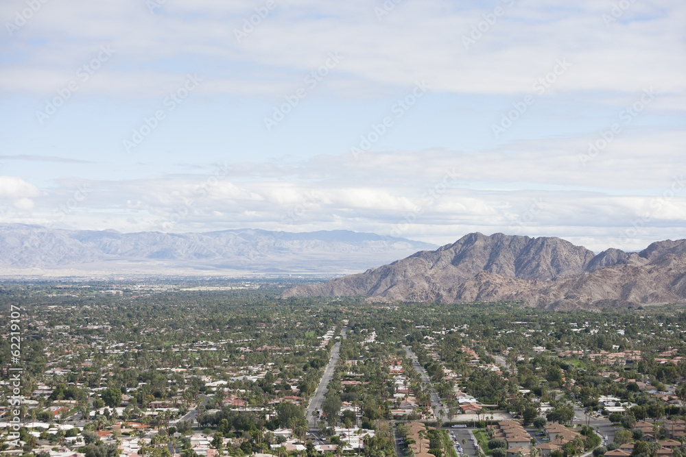 Residential district and mountains against cloudy sky Residential district and mountains against cloudy sky