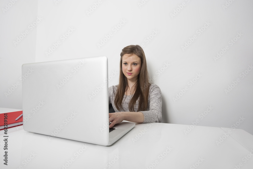 Beautiful businesswoman working on laptop at office desk Beautiful businesswoman working on laptop at office desk