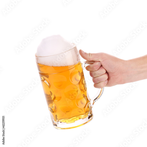 Mug of beer with froth in hand.