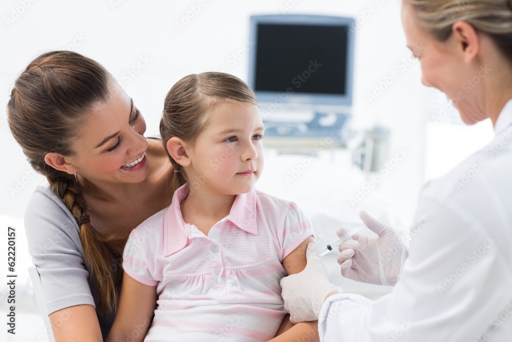 Girl receiving an injection by female doctor Girl receiving an injection by female doctor