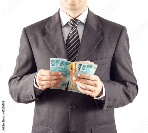 A businessman in a suit counting brazilian money photo