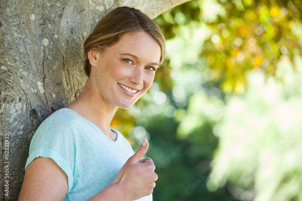 Happy woman gesturing thumbs up at park Happy woman gesturing thumbs up at park