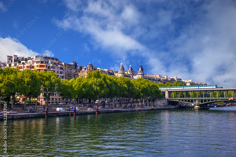 Obraz premium Famous quay of river Seine in Paris with buildings and trees.