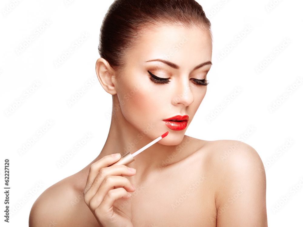 Beautiful young woman paints lips with lipstick. Perfect make-up Beautiful young woman paints lips with lipstick. Perfect make-up