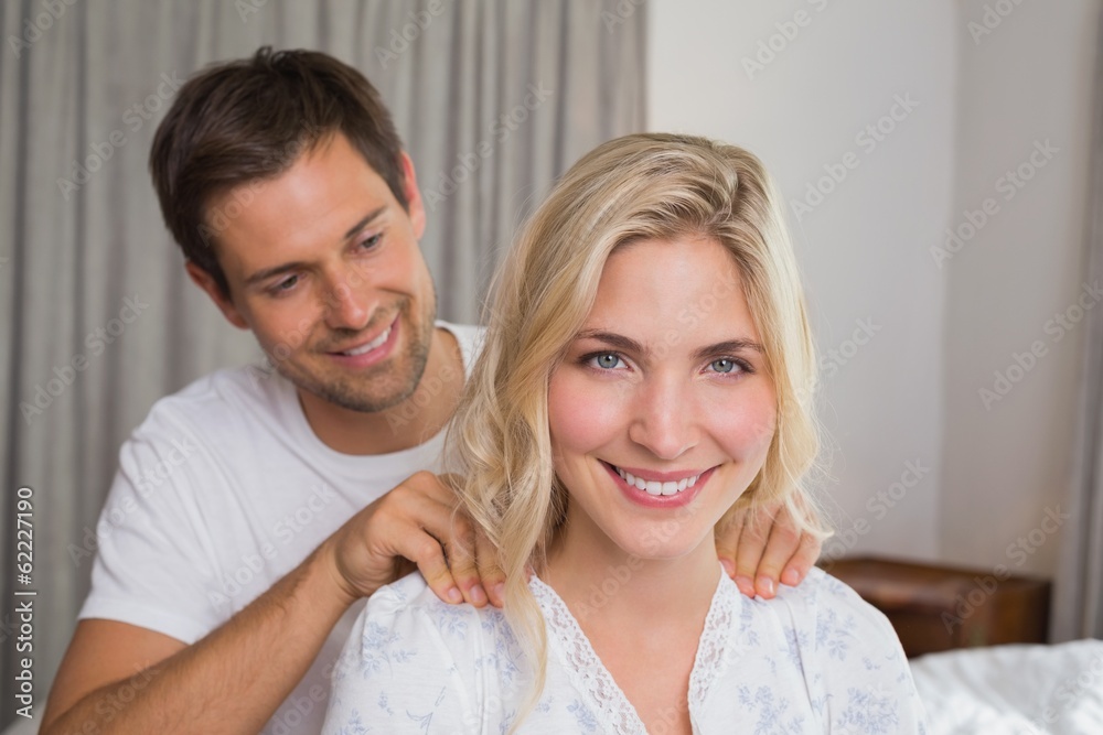 Smiling young man massaging woman's shoulders Smiling young man massaging woman's shoulders