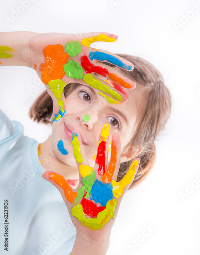 Beautiful little girl with hands in the paint