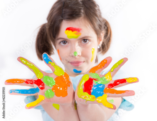 Beautiful little girl with hands in the paint