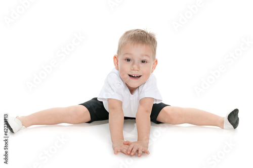Little boy performs gymnastic exercises