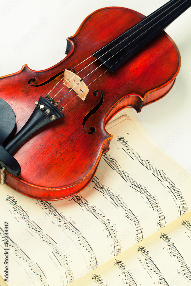 Fototapeta premium Vintage violin on sheet music background