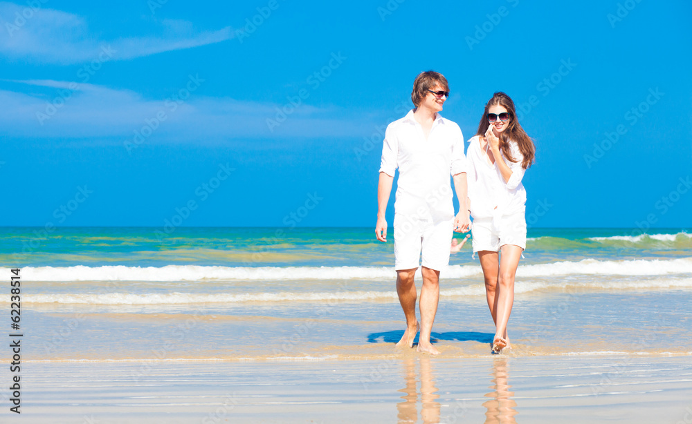 Front view of young happy caucasian couple in white walking on Front view of young happy caucasian couple in white walking on