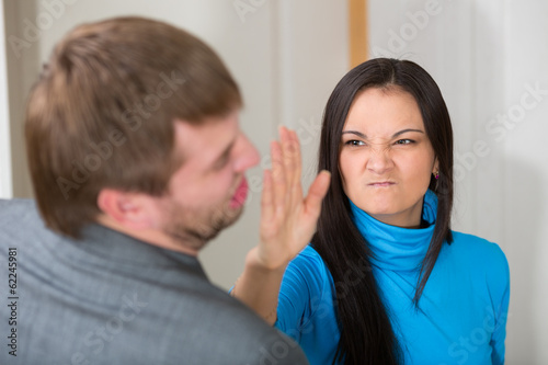 Woman about to slap her partner in living room photo