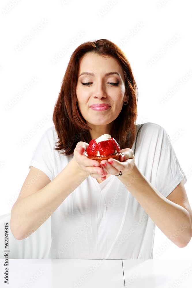 woman sitting at the table and holding fresh strawberry cake woman sitting at the table and holding fresh strawberry cake