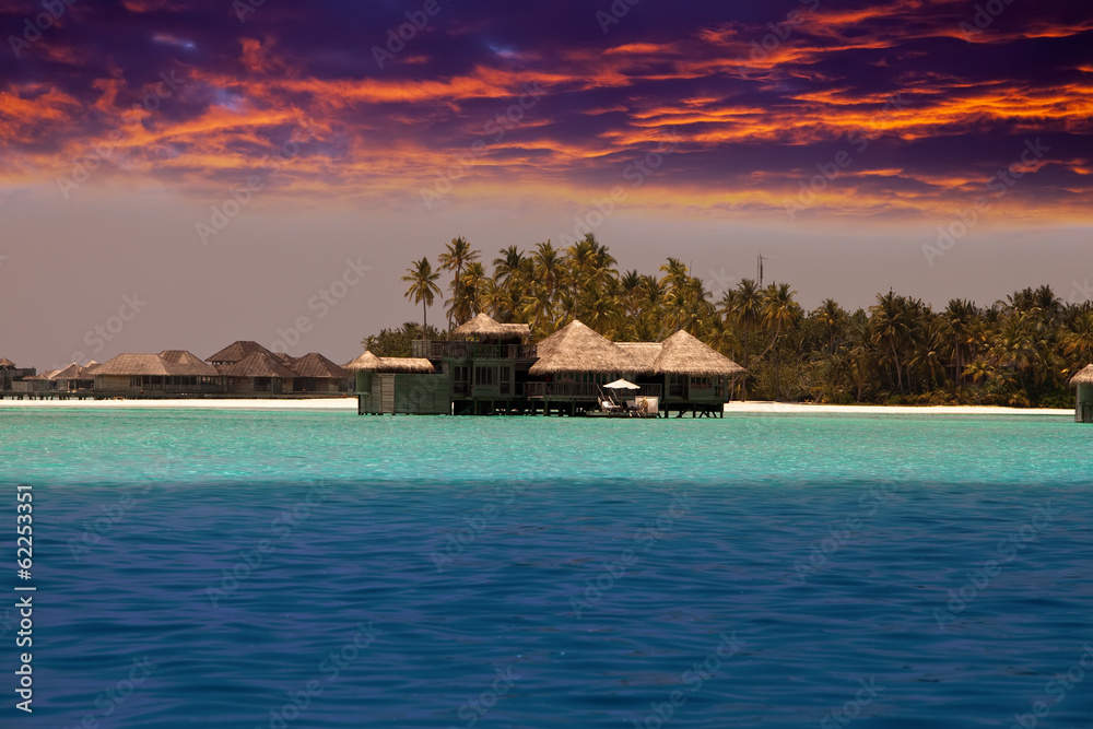 houses over the transparent quiet sea water  on a sunset