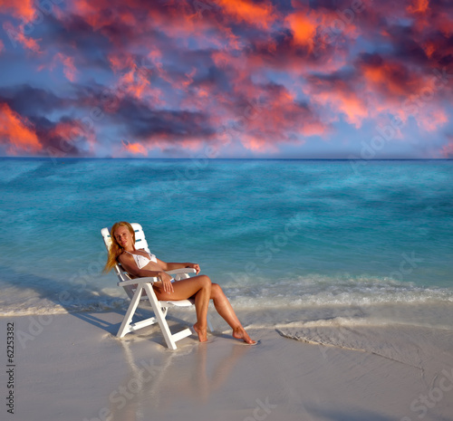 Young pretty woman in a beach chair at ocean.. photo