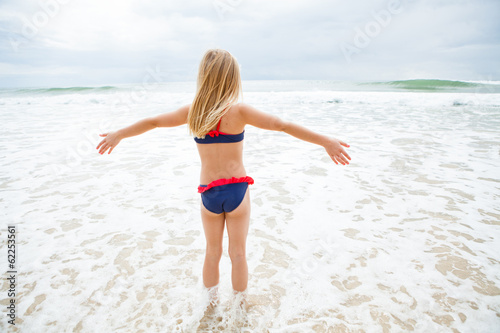Young girl standing in water at beach