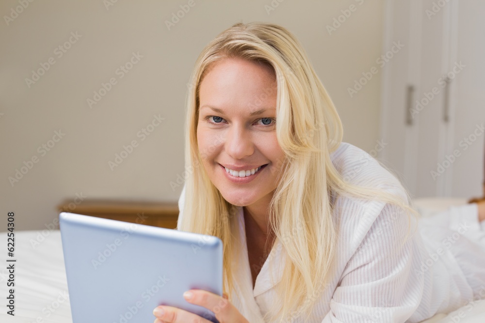 Woman using digital tablet in bed