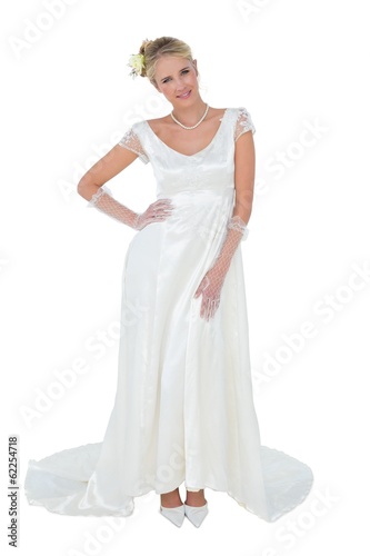 Beautiful bride with hand on waist over white background