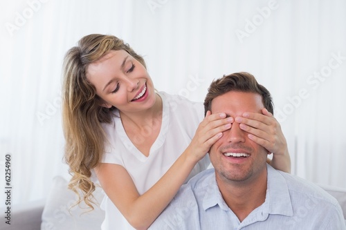 Young woman covering mans eyes