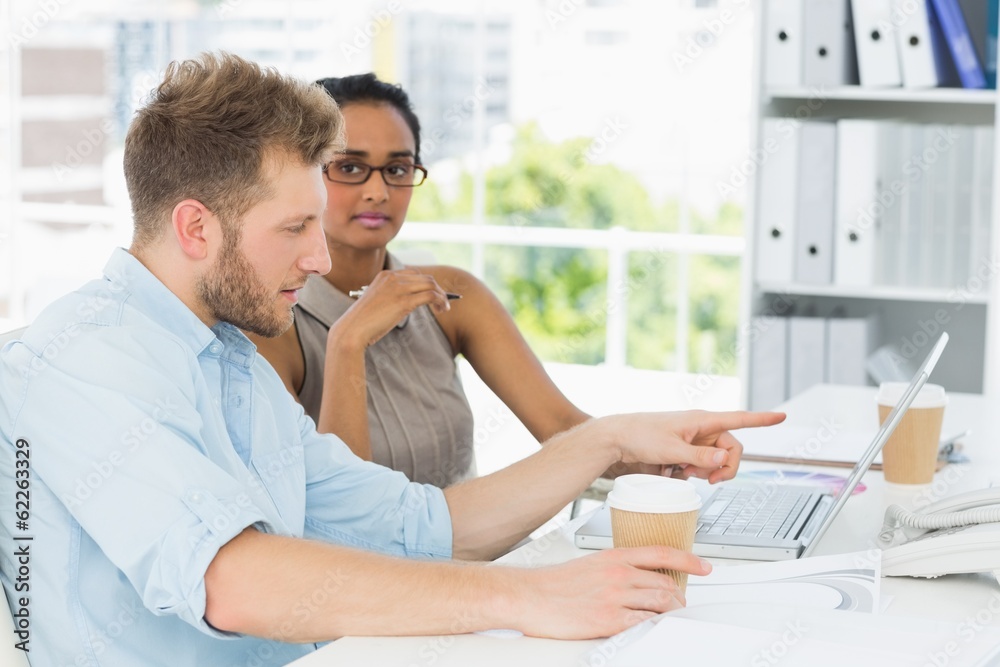 Fototapeta premium Casual business partners working together on laptop at desk