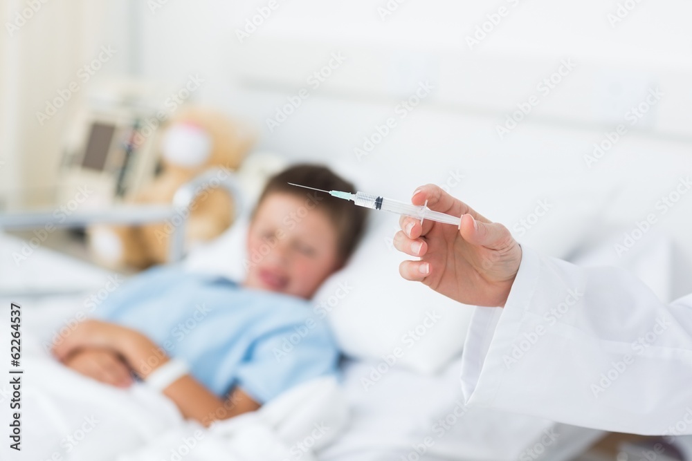 Doctor holding syringe with boy in hospital Doctor holding syringe with boy in hospital