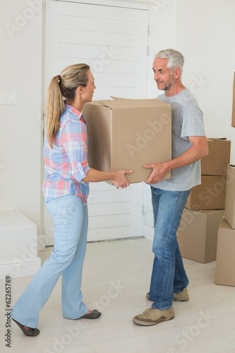 Happy couple carrying cardboard moving boxes © WavebreakMediaMicro
